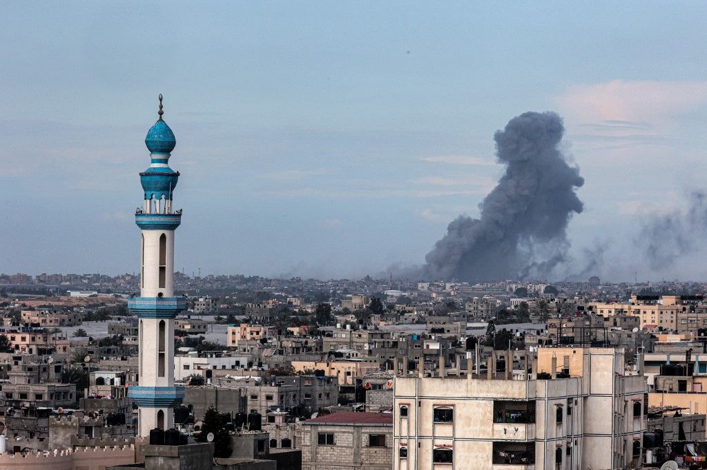 This picture taken from Rafah shows smoke billowing over Khan Yunis in the distance following Israeli bombardment on the southern Gaza Strip on February 14, 2024, amid the ongoing conflict between Israel and the Palestinian Hamas militant group. (Photo by SAID KHATIB / AFP)