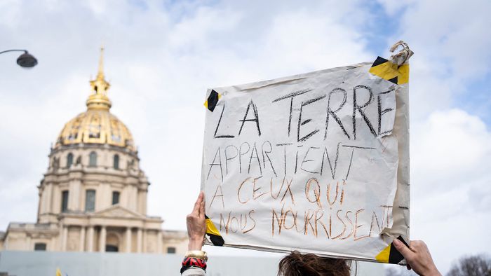 France, Paris, 2024-02-23. Sign THE LAND BELONGS TO THOSE WHO FEED US. Farmers protest one day before the opening of the Paris agriculture fair. Photography by Laure Boyer / Hans Lucas.France, Paris, 2024-02-23. Pancarte LA TERRE APPARTIENT A CEUX QUI NOUS NOURRISSENT. Manifestation d agriculteurs de la Coordination rurale la veille de l ouverture du Salon de l Agriculture de Paris. Place Vauban, 15e arrondissement. Photographie par Laure Boyer / Hans Lucas. (Photo by Laure Boyer / Hans Lucas / Hans Lucas via AFP)