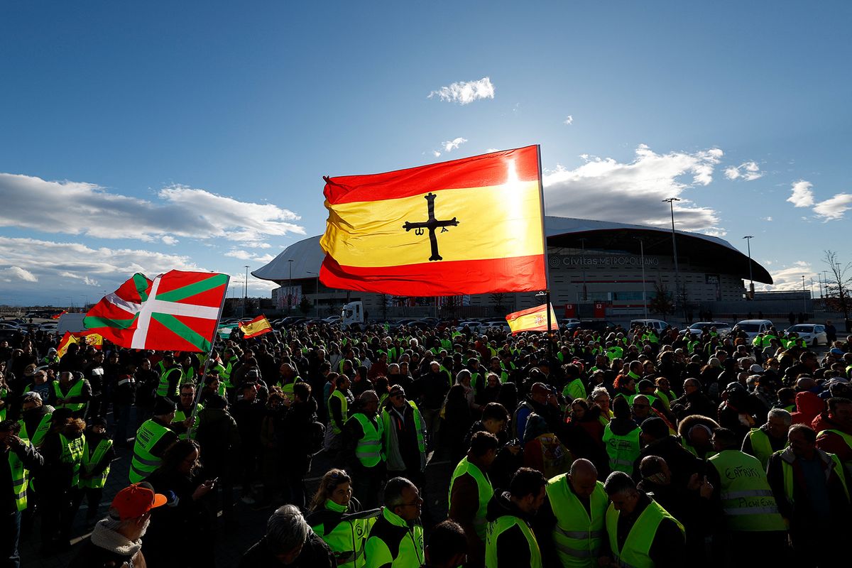Demonstrators wave an Ikurrina Basque regional flag and a Spanish flag as they gather during an ongoing farmers protest over heavy regulation and cheaper imports, in front of the Metropolitano stadium in Madrid on February 10, 2024. Angry farmers have been protesting across Europe over rising costs, high fuel prices, bureaucracy and the environmental requirements in the EU's Common Agricultural Policy (CAP) and its forthcoming "Green Deal". (Photo by OSCAR DEL POZO / AFP)