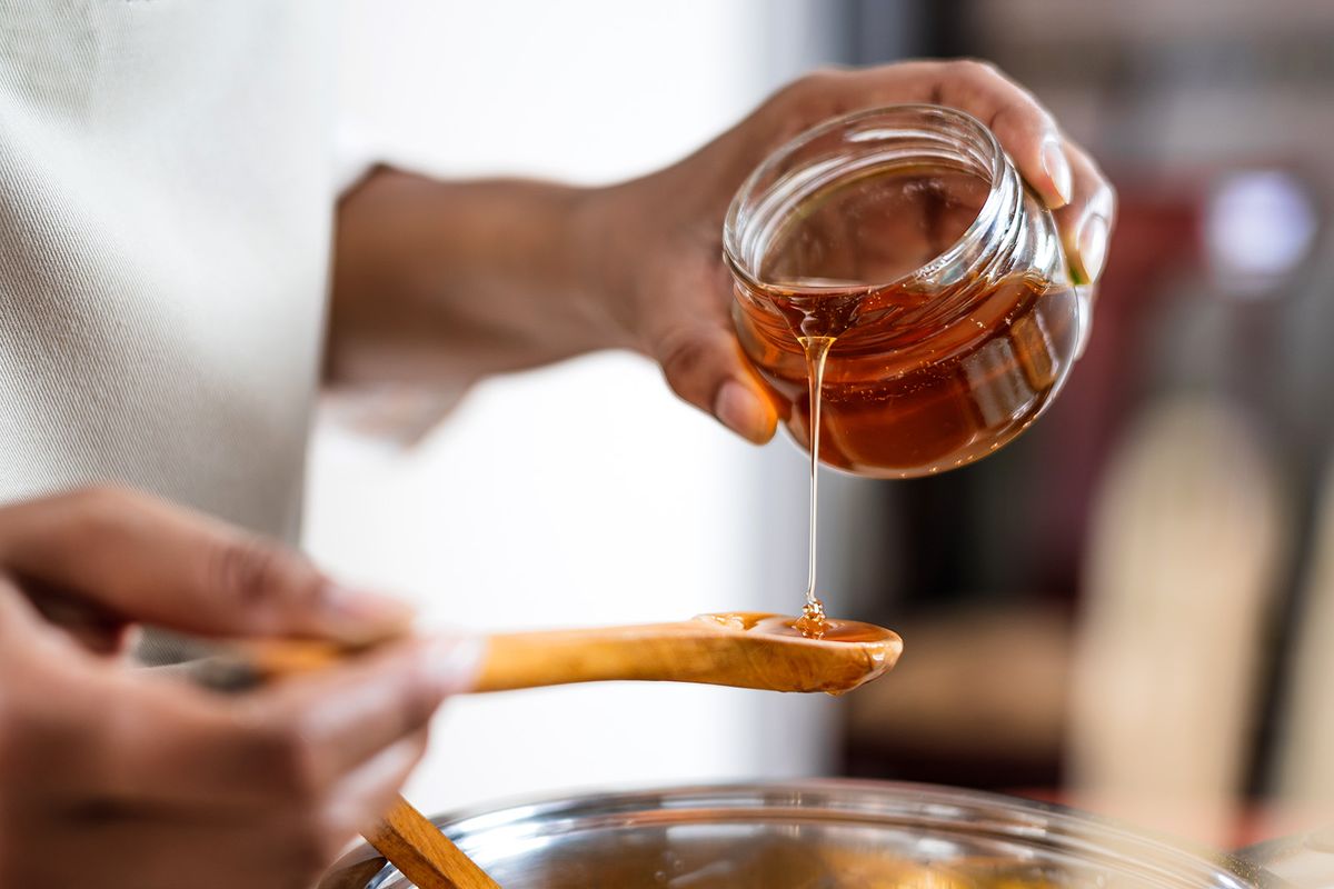 Female,Hands,Holding,A,Bowl,Of,Bee,Honey,And,
Female hands holding a bowl of bee honey and a wooden spoon. Close up. Elaboration of organic soap based on glycerin.