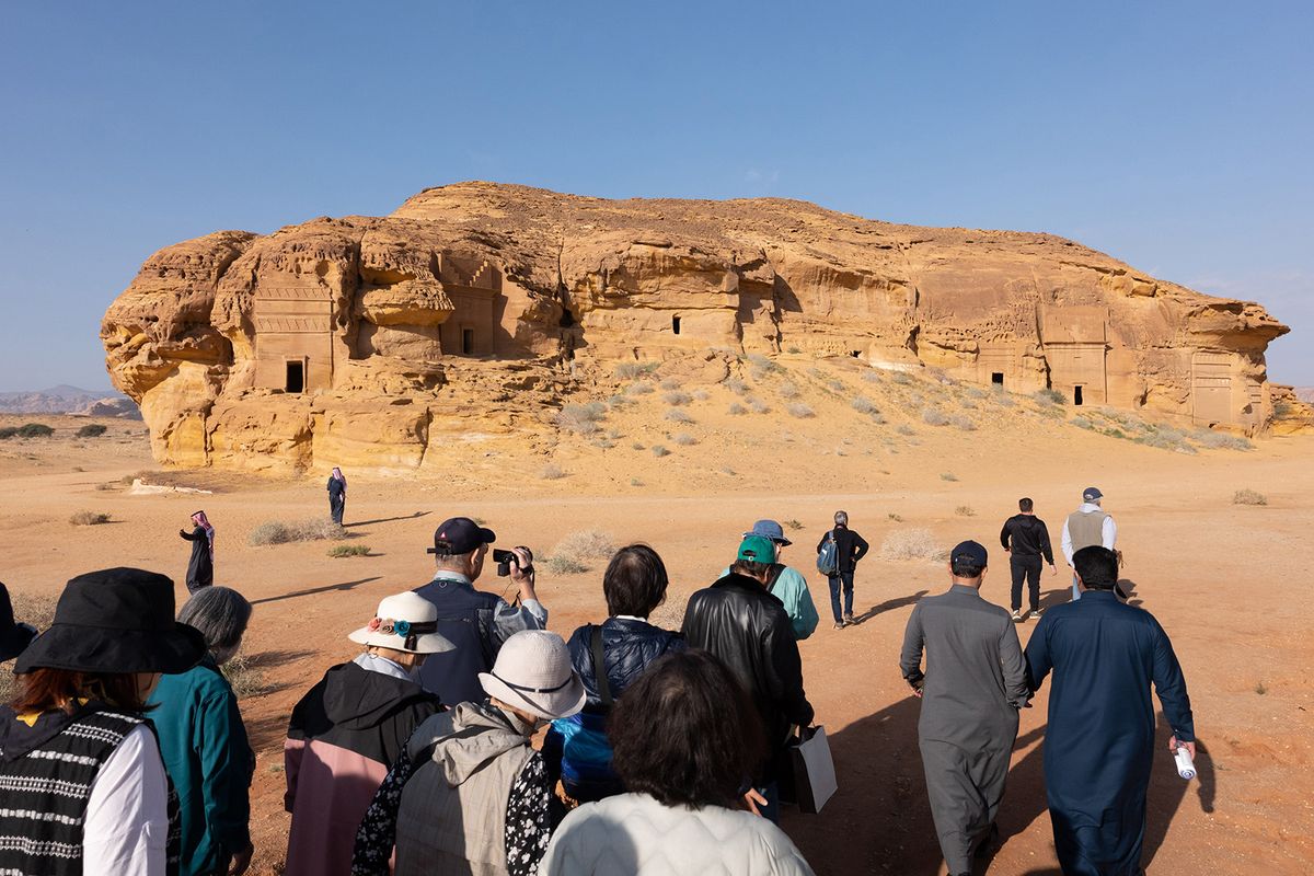 Tourists during a visit to the ancient archaeological site of Hegra in AlUla, Saudi Arabia, on Sunday, Jan. 22, 2023. In a country that until recently was largely closed off to foreign holidaymakers and entertainment was a taboo, the Public Investment Fund is investing in luxury resorts, cinemas and entertainment complexes to lure more tourists, and to stop Saudis seeking fun abroad. Photographer: Jeremy Suyker/Bloomberg via Getty Images