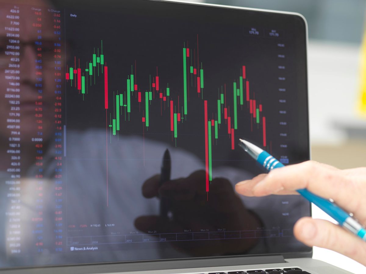 Reflection of a stock trader viewing the performance of a company share price on screen