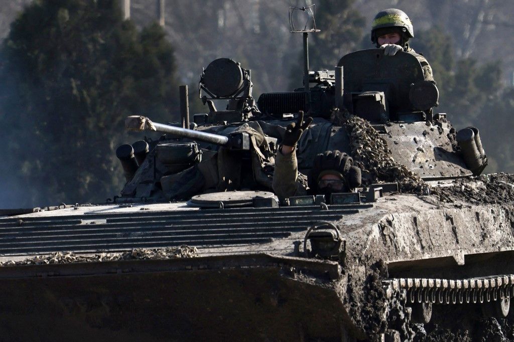 A Ukrainian serviceman flashes the sign of victory from an armoured combat vehicle on a road in the Donetsk region, amid the Russian invasion of Ukraine, on February 17, 2024. (Photo by Anatolii STEPANOV / AFP)