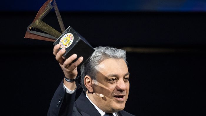 Renault group's general director Luca De Meo holds the trophy after Renault Scenic E-Tech electric model car awarded European Car of the Year 2024 by a panel of 59 automobile journalists representing 22 countries is pictured on February 26, 2024 ahead of the Geneva International Motor Show in Geneva. (Photo by Fabrice COFFRINI / AFP)