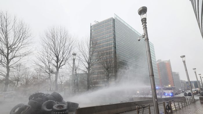 Riot police forces use water cannon at farmers during a protest called by the farmers' organizations 'Federation Unie de Groupements d'Eleveurs et d'Agriculteurs' (FUGEA), Boerenforum and MAP, in response to the European Agriculture Council, in Brussels, on February 26, 2024. Farmers across Europe have been protesting for weeks over what they say are excessively restrictive environmental rules, competition from cheap imports from outside the European Union and low incomes. (Photo by BENOIT DOPPAGNE / Belga / AFP) / Belgium OUT