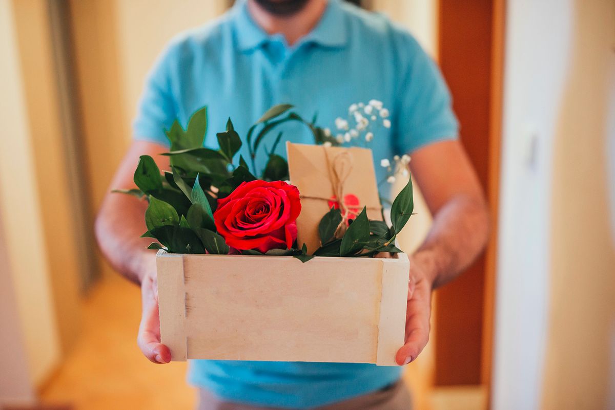 Мan courier delivering Flowers For Valentine`s Day