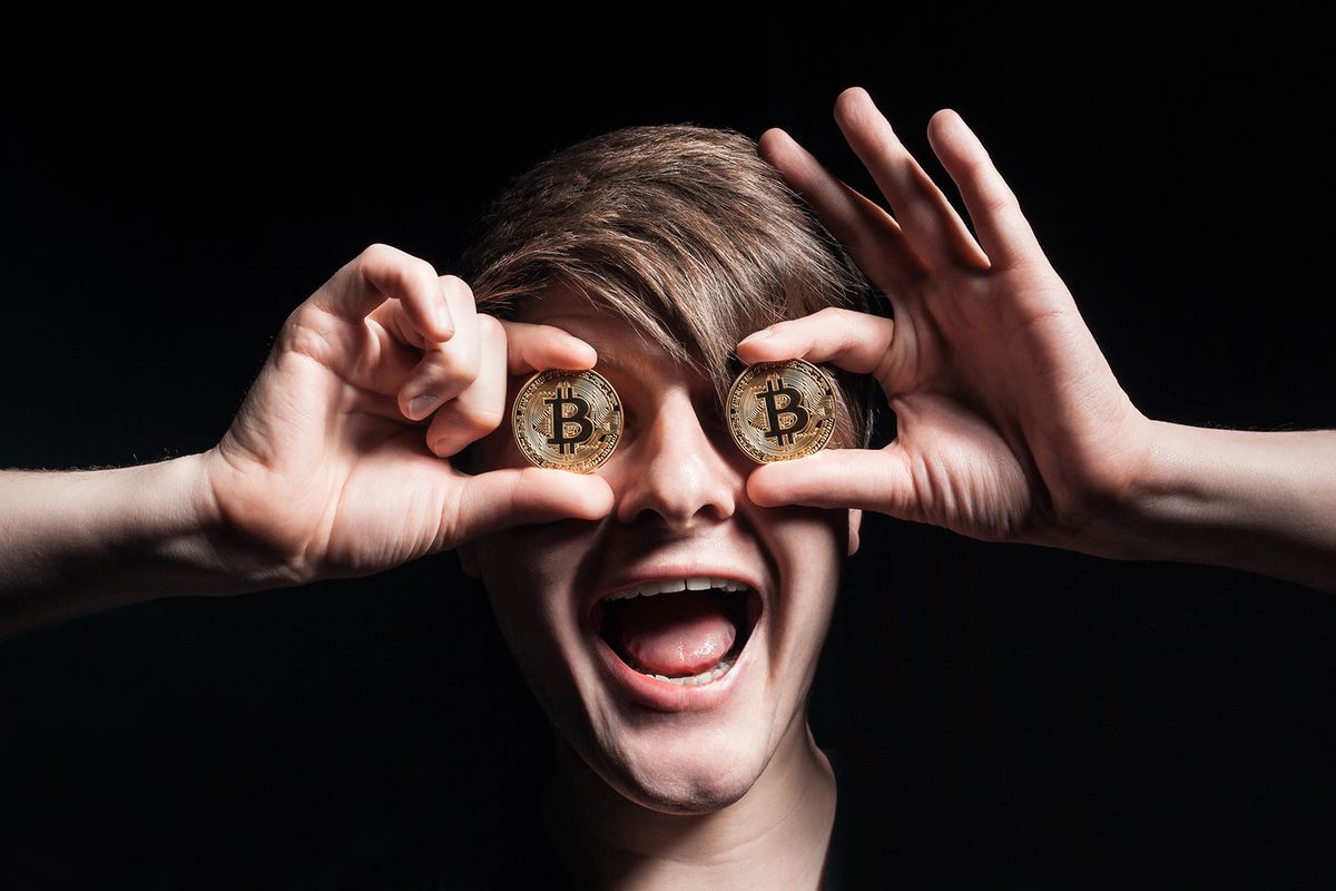 crazy bitcoin lover with golden coin by eyes; funny miner with btc near face; 