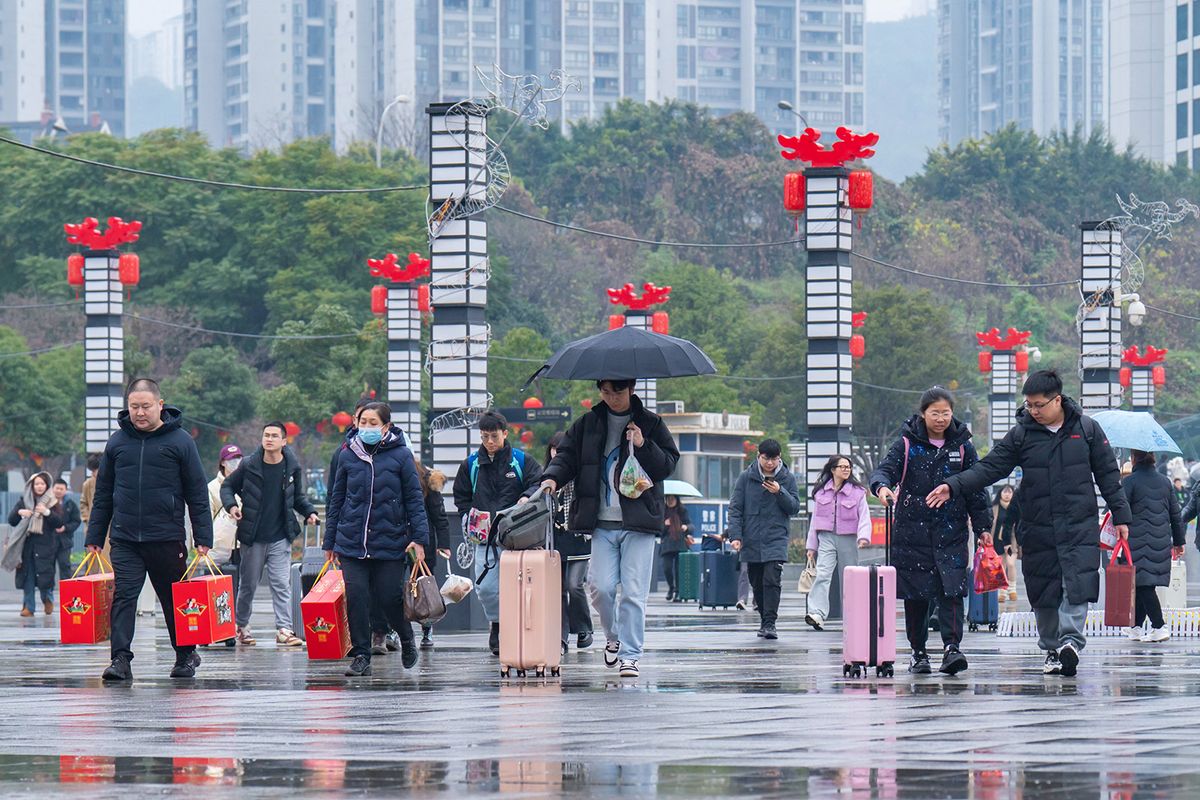 Passengers are dragging their luggage at the North Railway Station as they prepare to take the train home in Chongqing, China, on February 8, 2024. It is reported that on February 8, the 14th day of China's Spring Festival travel rush, China's railways are expected to transport 12.5 million passengers and operate an additional 1,900 passenger trains. (Photo by Costfoto/NurPhoto) (Photo by CFOTO / NurPhoto / NurPhoto via AFP)