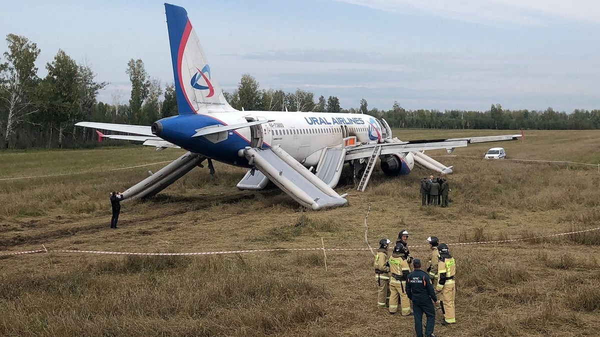 Law enforcement officers stand next to an Ural Airlines Airbus A320 passenger plane following its emergency landing in a field near the village of Kamenka, Novosibirsk region, on September 12, 2023. A Russian passenger Airbus A320 flying from the Black Sea resort of Sochi to the Siberian city of Omsk, with 167 people on board, made an emergency landing in an open Siberian field on September 12. Russia's aviation has been hard hit by Western sanctions over Moscow's Ukraine offensive. (Photo by Vladimir NIKOLAYEV / AFP) orosz