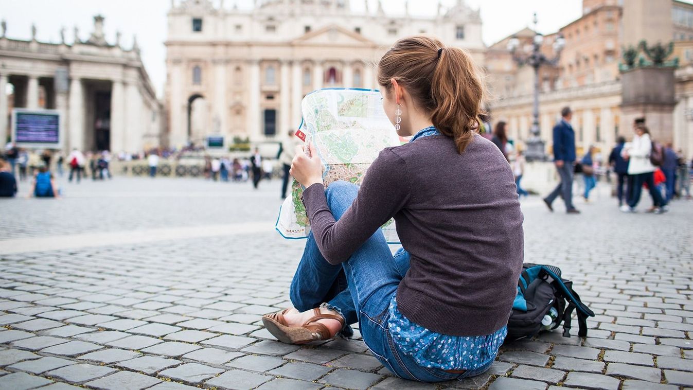 Pretty,Young,Female,Tourist,Studying,A,Map,At,St.,Peter'sPretty young female tourist studying a map at St. Peter's square in the Vatican City in Rome