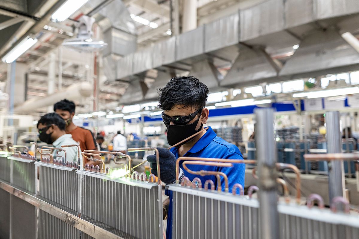 A worker welds at the air conditioner factory of Haier Appliances India Ltd., in Greater Noida, India, on Monday, May 8, 2023. Demand for air conditioners is surging in the country. Photographer: Anindito Mukherjee/Bloomberg via Getty Images