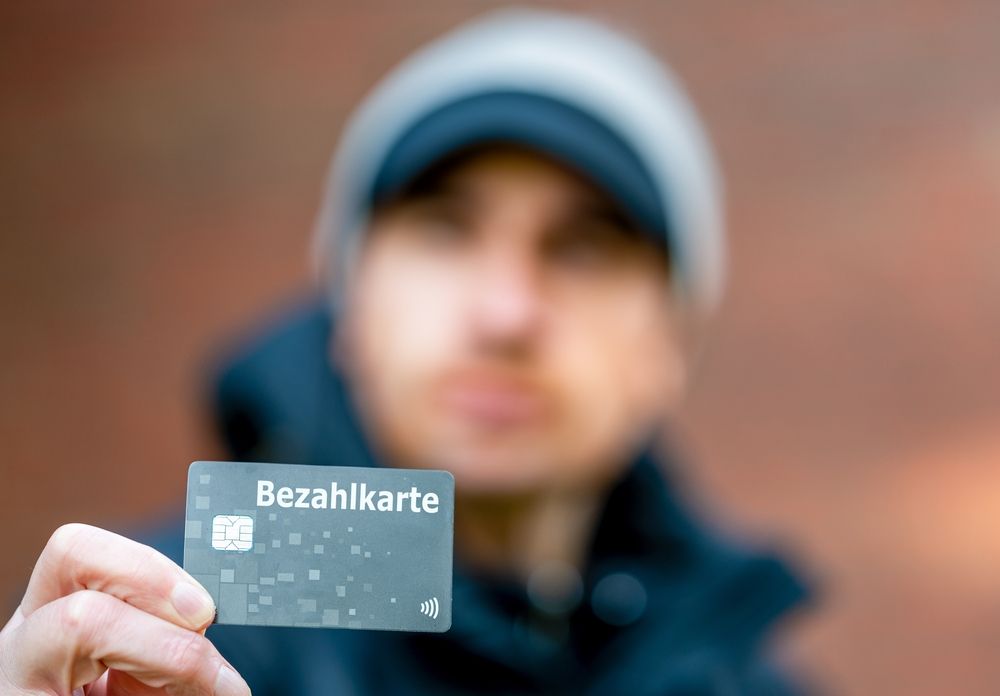 A,Refugee,With,A,Payment,Card,(bezahlkarte),In,Germany.,Symbol