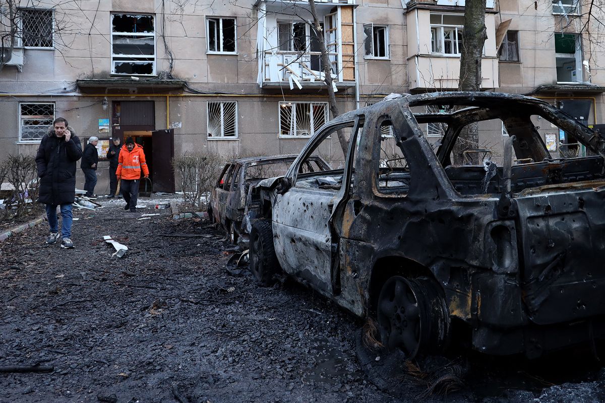 Local residents walk past destroyed cars in the courtyard of a residential building damaged following a drone attack in Odesa on January 17, 2024. Kyiv said on January 17, 2024 that Russia had launched 20 Iranian-designed attack drones at targets in southern Ukraine overnight, and that its air defence systems destroyed all but one. (Photo by Oleksandr GIMANOV / AFP)