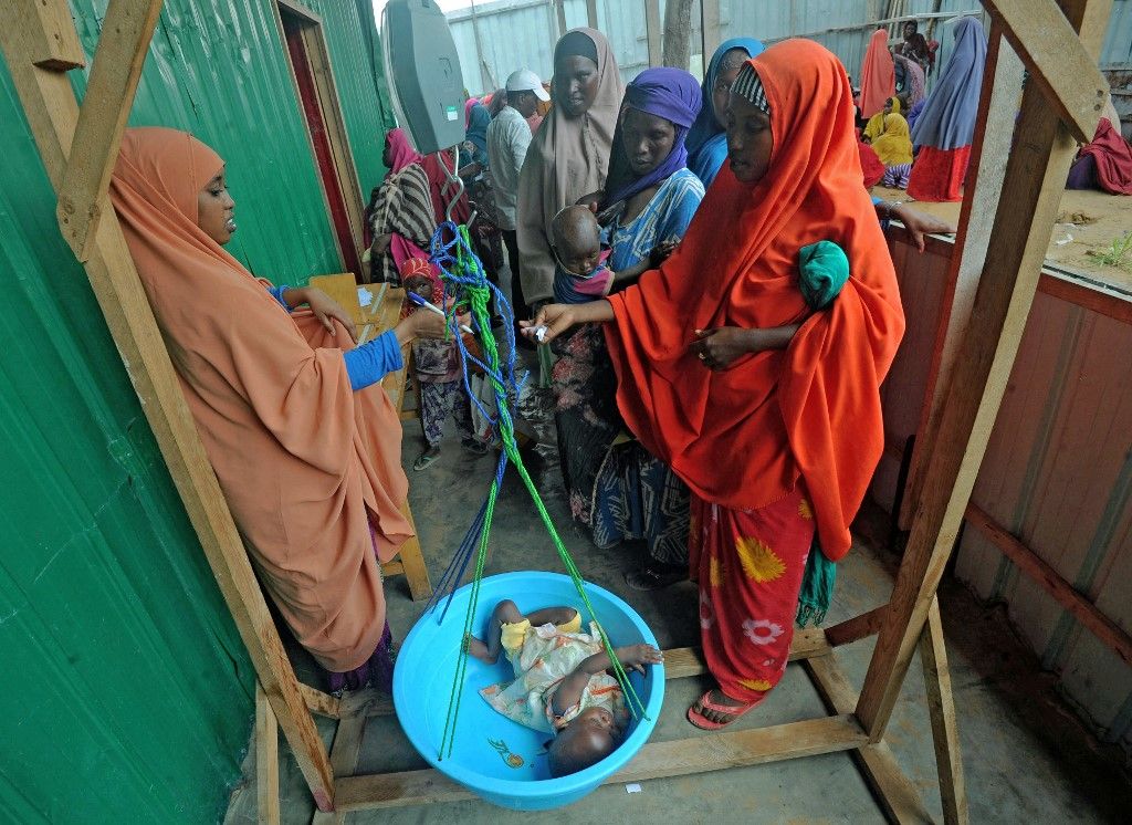 Newly displaced Somali women weigh their malnourished children as they try to receive medical treatment on the outskirts of Mogadishu on April 11, 2017. The United Nations warned on April 11 of a growing risk of mass deaths from starvation among people living in conflict and drought-hit areas of the Horn of Africa, Yemen and Nigeria. UNHCR's operations in famine-hit South Sudan, and in Nigeria, Somalia and Yemen, which are on the brink of famine, are funded at between just three and 11 percent, said UN refugee agency spokesman Adrian Edwards, as the UN faces a "severe" funding shortfall to help people affected by famine. (Photo by MOHAMED ABDIWAHAB / AFP)