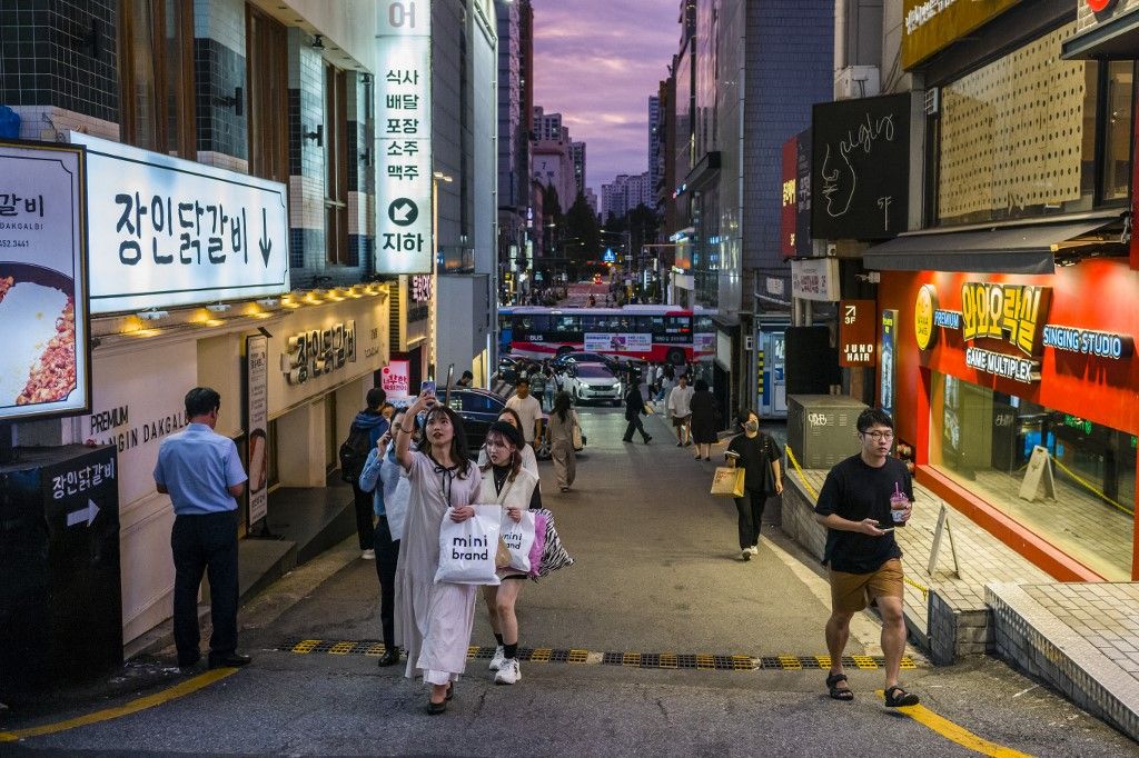 Pedestrians walk on a street in the Gangnam district of Seoul on September 14, 2023. Seoul's Gangnam district, which was made famous by rapper Psy's global hit "Gangnam Style”, is an upscale district known for its luxury boutiques and apartments. (Photo by ANTHONY WALLACE / AFP)