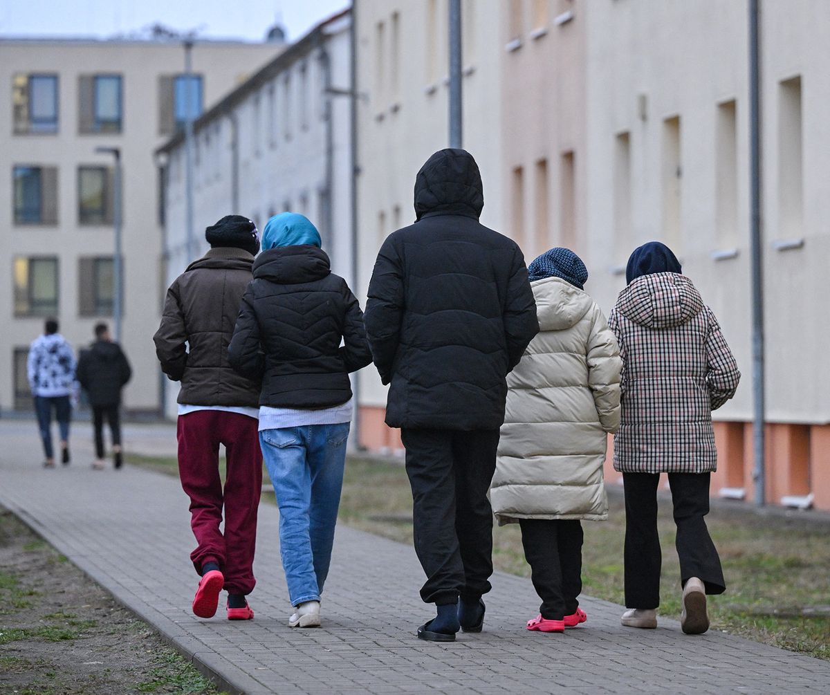 14 December 2023, Brandenburg, Eisenhüttenstadt: Migrants walk across the grounds of the Central Reception Center for Asylum Seekers (ZABH) of the state of Brandenburg in Eisenhüttenstadt. Photo: Patrick Pleul/dpa (Photo by PATRICK PLEUL / DPA / dpa Picture-Alliance via AFP)