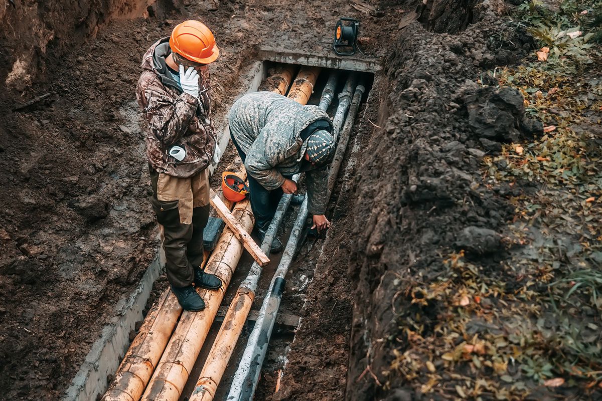 Two,Workers,Change,Public,Water,Pipes,In,Trench,On,Rainy