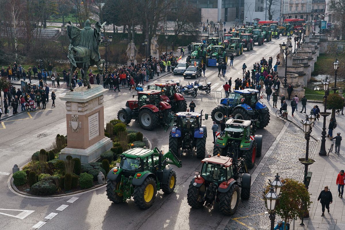 Spanish farmers drive their tractors past the El Cid Campeador statue during a protest in demand of fair conditions for the agricultural sector, in Burgos, northern Spain, on February 6, 2024. Thousands of farmers began demonstrating at dawn in different regions of Spain, blocking several roads with tractors to protest against European agricultural policy and denounce the precariousness reigning in the sector. (Photo by CESAR MANSO / AFP)