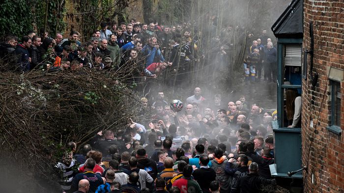 Competitors from the opposing teams, the Up'ards and the Down'ards, fight for the ball during the annual Royal Shrovetide Football Match in Ashbourne, northern England, on February 13, 2024. The mass-participation ball game involves two teams, whose players are defined by which side of a small brook that bisects the town they were born, aiming to score a goal, which are some three miles apart. The game, which has very few rules, is played over two 8 hour periods on Shrove Tuesday and Ash Wednesday. Royal Shrovetide Football is believed to have been played annually in Ashbourne since 1667.
