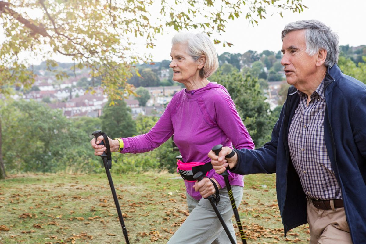 Senior couple exercising,walking through parkland, united kingdom