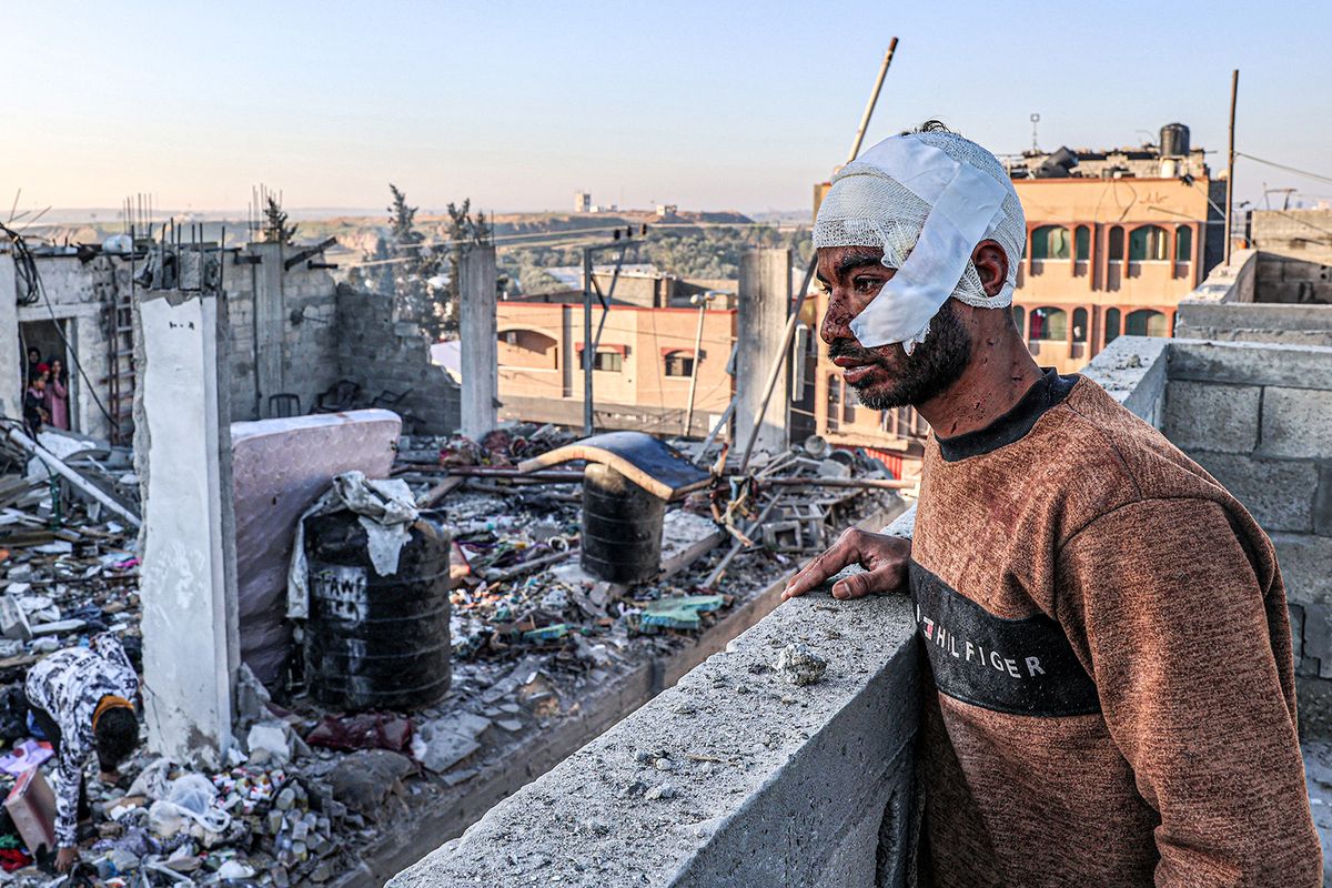 An injured man with a bandaged head looks on while standing next to the rubble and debris of a destroyed building in the aftermath of Israeli bombardment on Rafah in the southern Gaza Strip on February 7, 2024, amid the ongoing conflict between Israel and the Palestinian militant group Hamas. (Photo by SAID KHATIB / AFP)