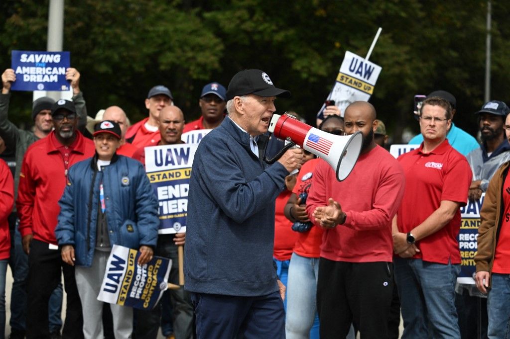 US President Joe Biden addresses striking members of the United Auto Workers (UAW) union at a picket line outside a General Motors Service Parts Operations plant in Belleville, Michigan, on September 26, 2023. Some 5,600 members of the UAW walked out of 38 US parts and distribution centers at General Motors and Stellantis at noon September 22, 2023, adding to last week's dramatic worker walkout. According to the White House, Biden is the first sitting president to join a picket line. (Photo by Jim WATSON / AFP)