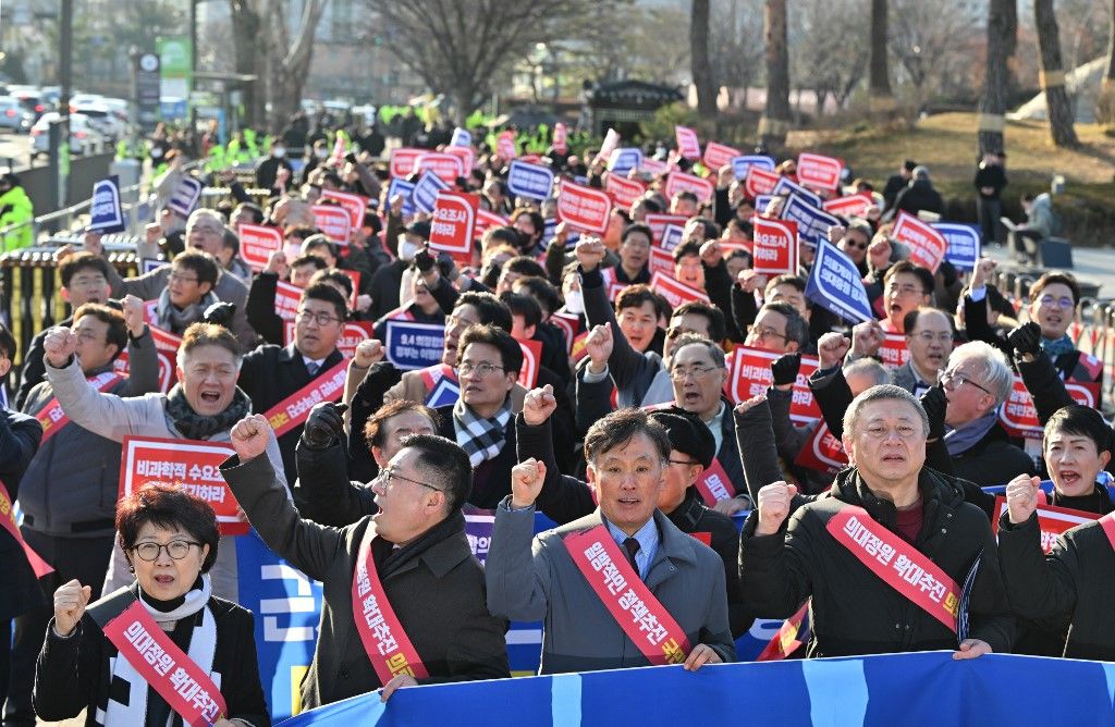 Doctors shout slogans during a rally to protest against the government’s plan to raise the annual enrolment quota at medical schools, near the Presidential Office in Seoul on February 25, 2024. South Korea has raised its public health alert to the highest level, authorities announced on February 23, saying health services were in crisis after thousands of doctors resigned over proposed medical reforms. (Photo by Jung Yeon-je / AFP)