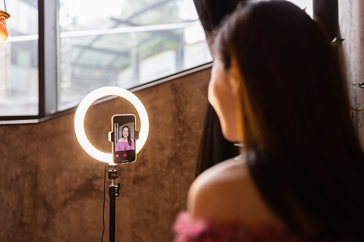 Young,Woman,Making,Photo,Or,Video,Content,For,Social,Media
Young woman making photo or video content for social media with smartphone and light of ring lamp. Beauty blogger smiles to mobile phone screen. Influencer Makes broadcast communicates with followers