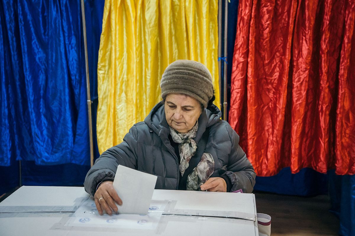A woman casts her ballot at a polling station in Bucharest during presidential elections on November 24, 2019. Romanians voted in the second round of presidential elections that are expected to return incumbent Klaus Iohannis to office, confirming the pro-European trajectory of the eastern EU member state. (Photo by Andrei PUNGOVSCHI / AFP)