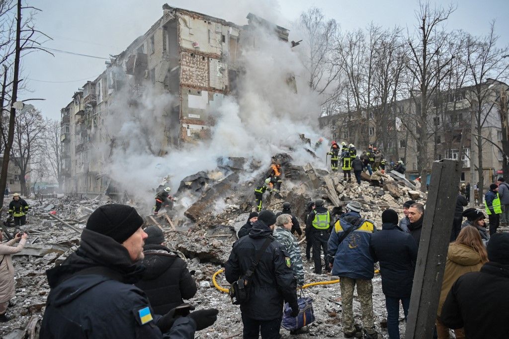Ukrainian rescue and emergency workers attend the site of a missile attack in Kharkiv on January 23, 2024. Dozens of people were injured and two killed following an overnight aerial barrage by Russian forces targeting the Ukrainian capital Kyiv and the second-largest city Kharkiv, officials said on January 23, 2024. (Photo by SERGEY BOBOK / AFP)