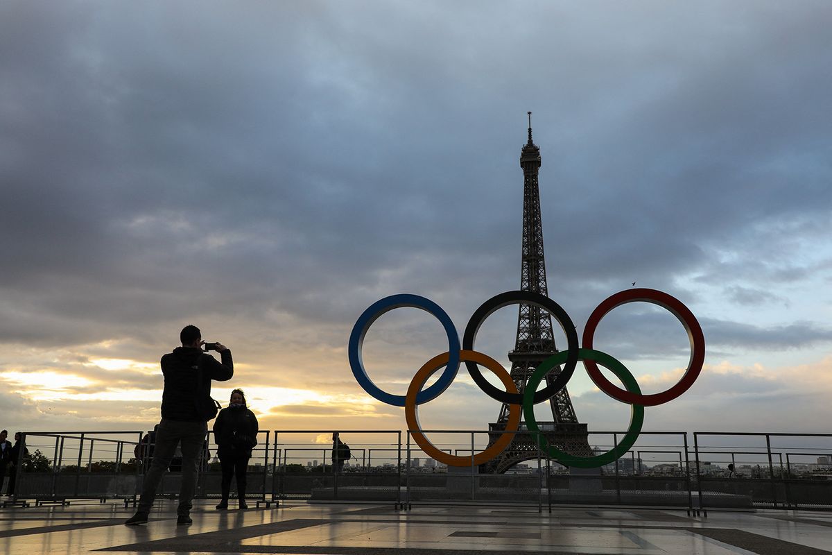People take photos at sunrise by the Olympic rings installed on the Esplanade du Trocadero near the Eiffel tower following the Paris' nomination as host for the 2024 Olympics, on September 14, 2017 in Paris. (Photo by LUDOVIC MARIN / AFP)