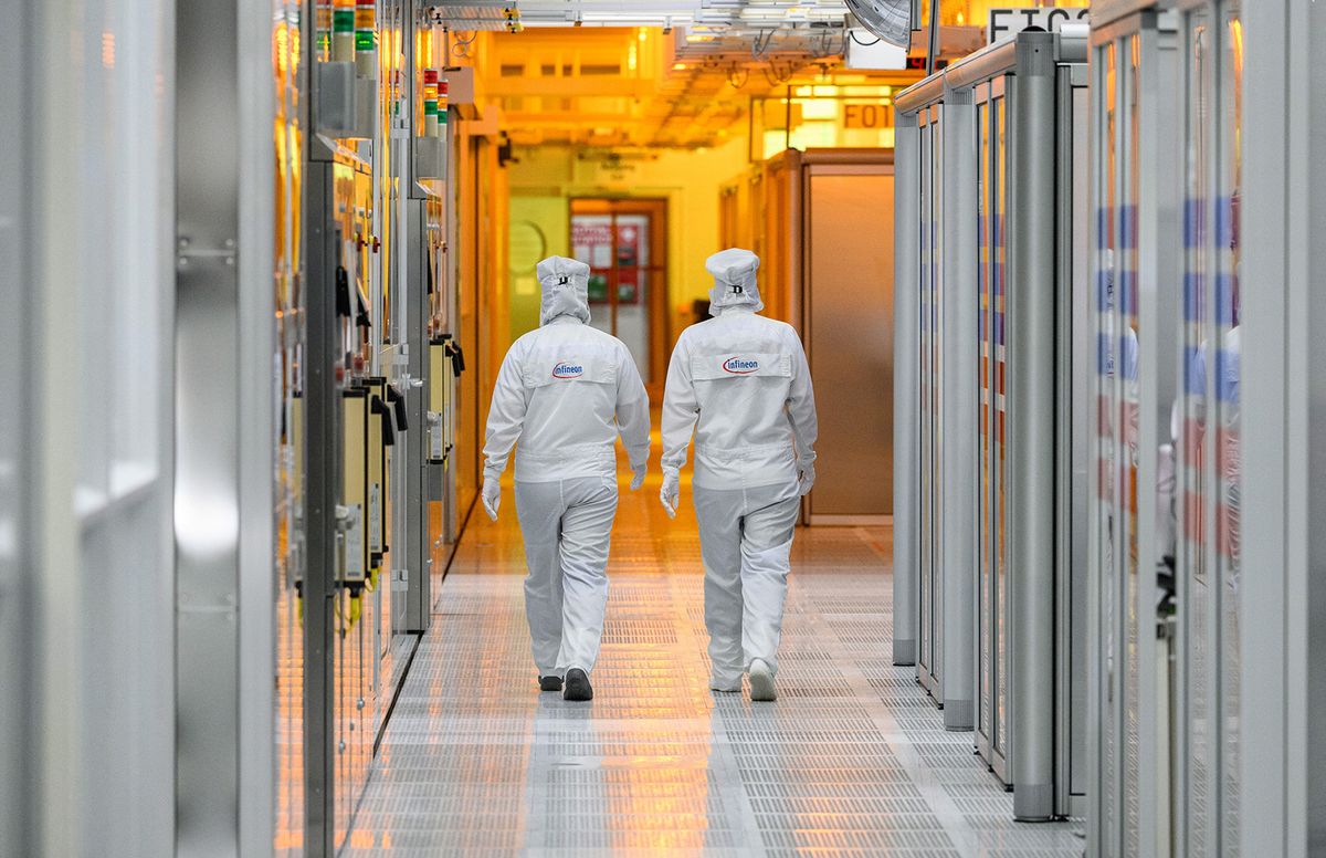 PRODUCTION - 26 April 2023, Saxony, Dresden: Female employees of the chip company Infineon walk along the clean room of the chip factory. Infineon breaks ground for the new Smart Power Fab in Dresden on May 2, 2023. Photo: Robert Michael/dpa (Photo by ROBERT MICHAEL / DPA / dpa Picture-Alliance via AFP)