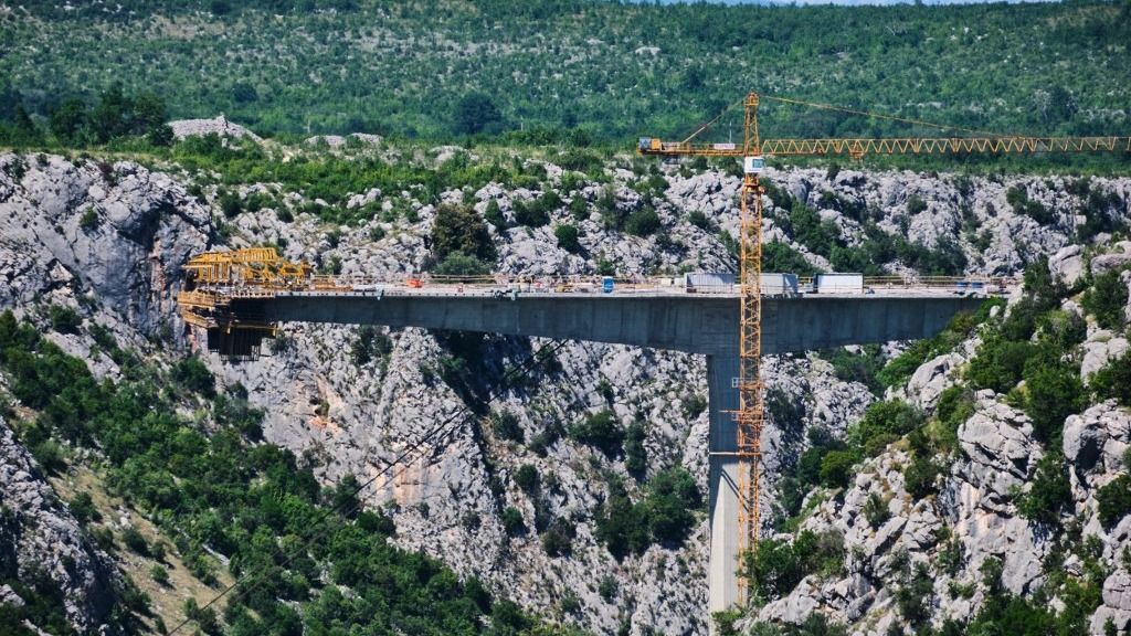 BOSNIA AND HERZEGOVINA - A HIGHWAY BRIDGE IS BUILT BEHIND THE CITADEL OF POCITELJ