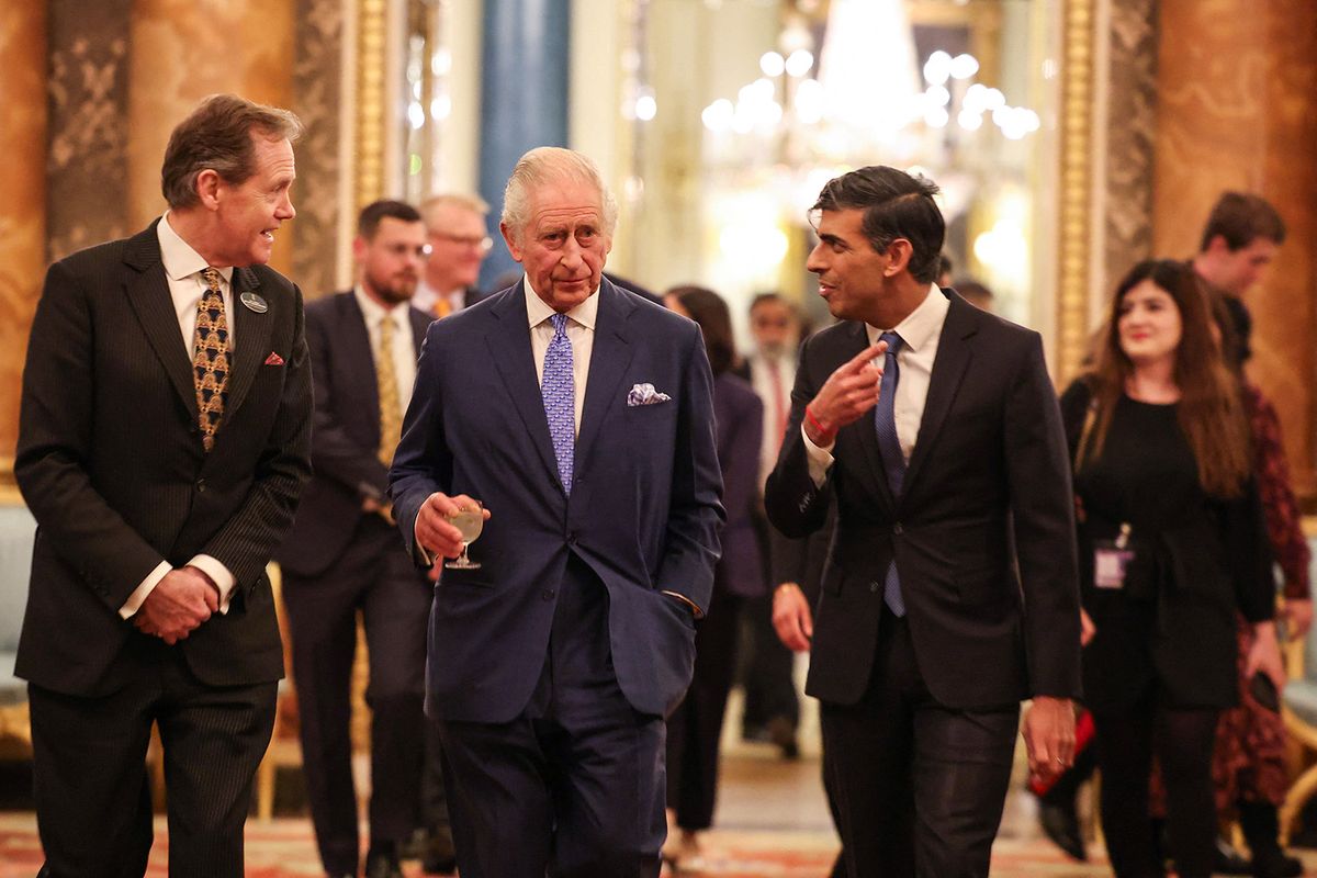 Britain's King Charles III (C) arrives with Britain's Prime Minister Rishi Sunak (R) as he hosts a reception at Buckingham Palace, in central London, on November 27, 2023 to mark the conclusion of the Global Investment Summit (GIS). (Photo by Daniel LEAL / POOL / AFP)