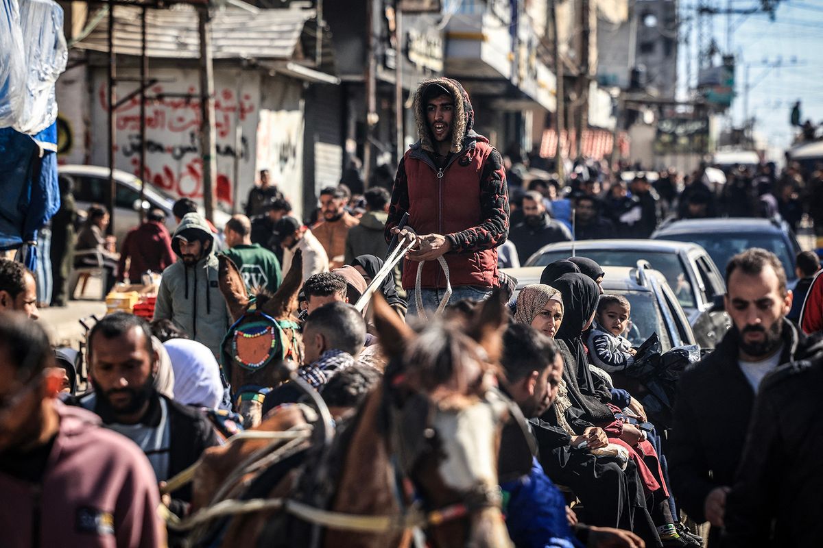 People who fled fighting in the Gaza Strip gather along an overcrowded street in Rafah in the southern part of the Palestinian territory on February 1, 2024, as battles between Israel and the militant group Hamas continue. (Photo by Mahmud Hams / AFP)