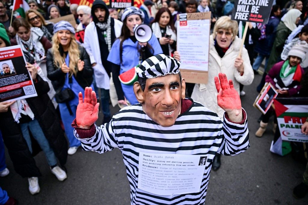 A demonstrator wearing a mask depicting Britain's Prime Minister Rishi Sunak and dressed with a prisoner uniform takes part in a National March for Palestine in central London on February 3, 2024. Deadly strikes were reported today in the overcrowded Gaza border town of Rafah -- dubbed a "pressure cooker of despair" by the UN -- as international mediators read