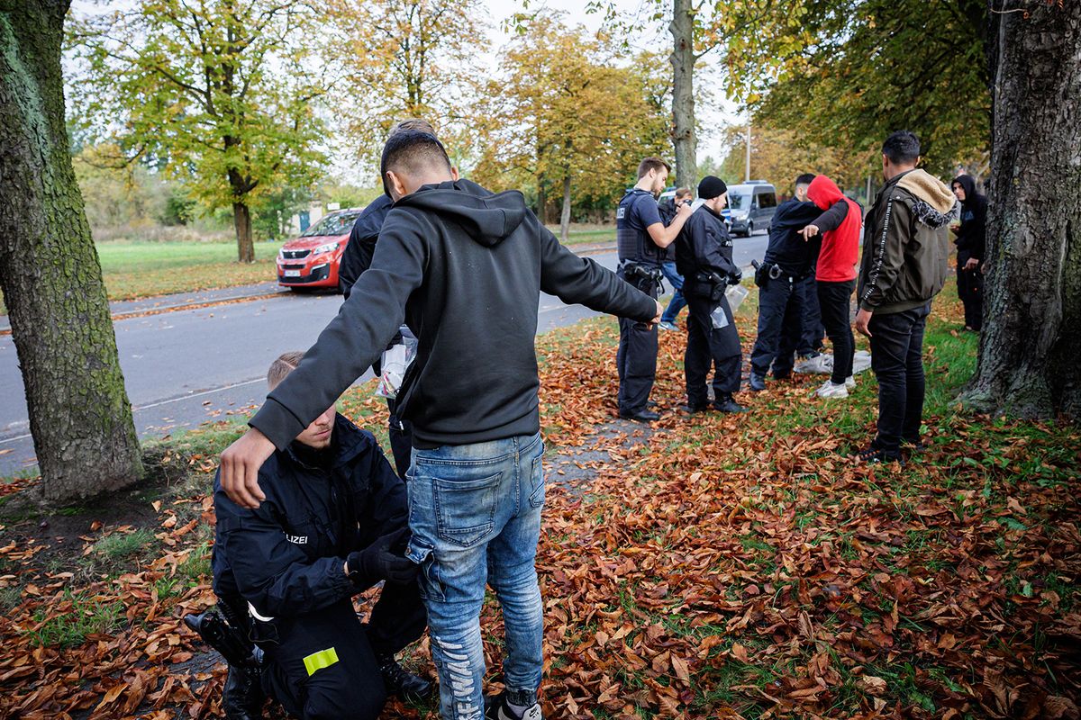 Officers of the German Federal Police (Bundespolizei) frisk a group of migrants near Forst, eastern Germany, on October 11, 2023, during a patrol near the border with Poland. The new influx has pushed Germany's government to take steps to limit entries into Germany, reignited a bitter debate over immigration and given a push to the far right in the polls. (Photo by JENS SCHLUETER / AFP)Officers of the German Federal Police (Bundespolizei) frisk a group of migrants near Forst, eastern Germany, on October 11, 2023, during a patrol near the border with Poland. The new influx has pushed Germany's government to take steps to limit entries into Germany, reignited a bitter debate over immigration and given a push to the far right in the polls. (Photo by JENS SCHLUETER / AFP)