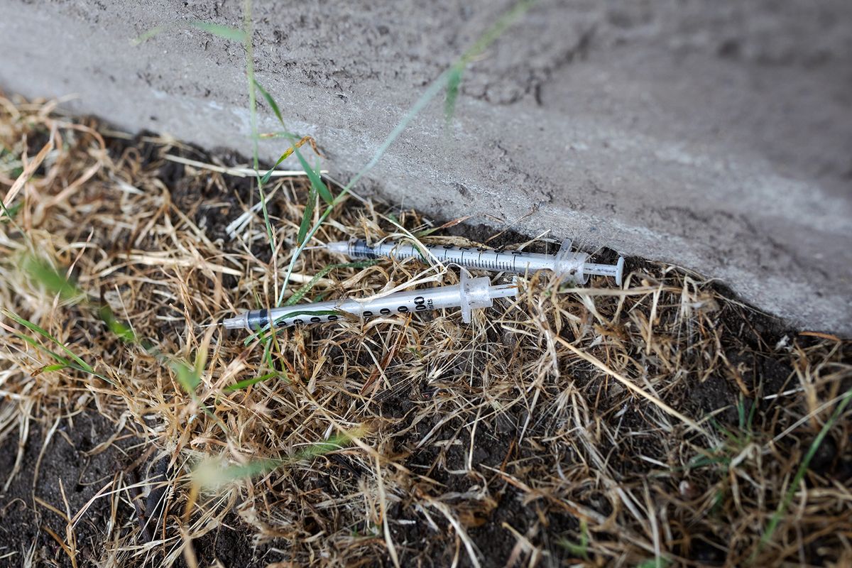 Used,Empty,Needle,Syringe,Dumped,In,The,Dry,Grass,By