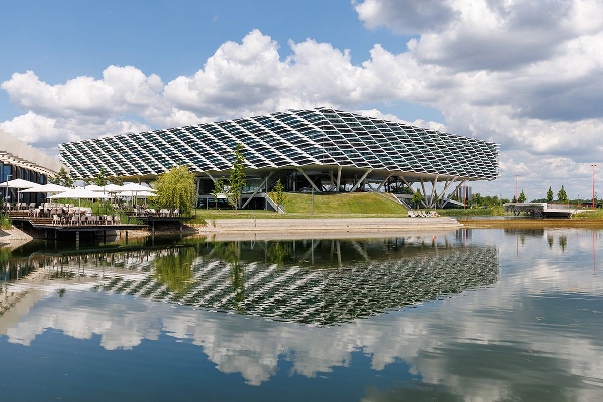 10 June 2022, Bavaria, Herzogenaurach: The "Arena" office building at the headquarters of the sporting goods manufacturer adidas AG is reflected in an artificial lake. Photo: Daniel Karmann/dpa (Photo by DANIEL KARMANN / DPA / dpa Picture-Alliance via AFP)