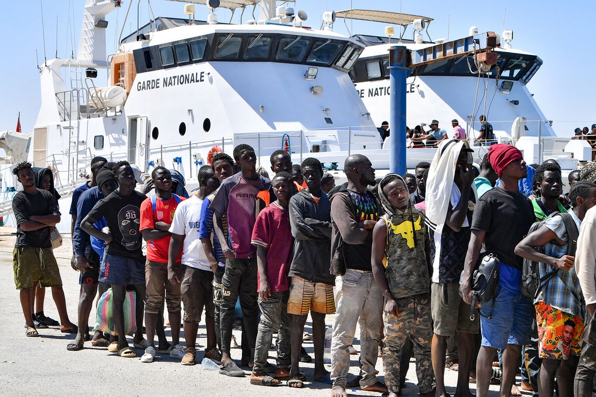 Migrants of African origin trying to flee to Europe, disembark in Sfax from a ship owned by the Tunisian coast guards, after being intercepted by them at sea on August 10, 2023. Mediterranean Sea crossing attempts from Tunisia have multiplied following a incendiary speech by the Tunisian president who had alleged that "hordes" of irregular migrants were causing crime and posing a demographic threat to the mainly Arab country. (Photo by FETHI BELAID / AFP)
