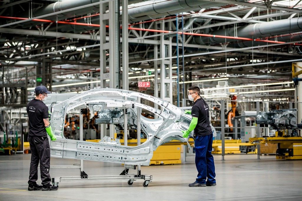In this handout picture released on April 28, 2020 by the Mercedes-Benz factory in Kecskemet, Hungary, employees wearing their protection masks prepare a frame of a car body in the factory of German car maker Mercedes-Benz on March 24, 2020. Hungarian factory of Mercedes restarted operations at its plant on April 28, 2020. The production was suspended in middle of March here amid the new coronavirus COVID-19 pandemic. (Photo by Dudar SZILARD / MERCEDES-BENZ / AFP) / RESTRICTED TO EDITORIAL USE - MANDATORY CREDIT "AFP PHOTO / MERCEDES-BENZ / DUDAR SZILARD " - NO MARKETING - NO ADVERTISING CAMPAIGNS - DISTRIBUTED AS A SERVICE TO CLIENTS