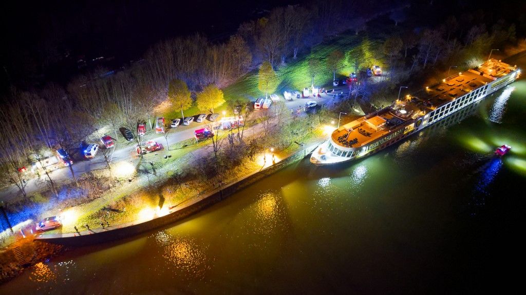 An aerial photo shows a Bulgarian cruise ship in the lock area after it crashed into a concrete wall in the night of March 29, 2024, in Aschach an der Donau, upper Austria. 17 of the about 160 passengers were injured and eleven were taken to the hospital. The ship was travelling from Bavaria towards Linz when it was apparently briefly unable to manoeuvre. (Photo by MARTIN SCHARINGER/TEAM FOTOKERSCHI / APA / AFP) / Austria OUT