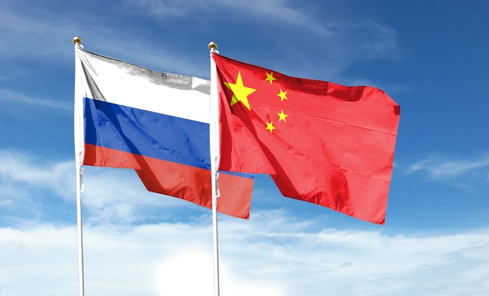 Russian,Flag,And,Chinese,Flag,On,The,Cloudy,Sky.,Wave