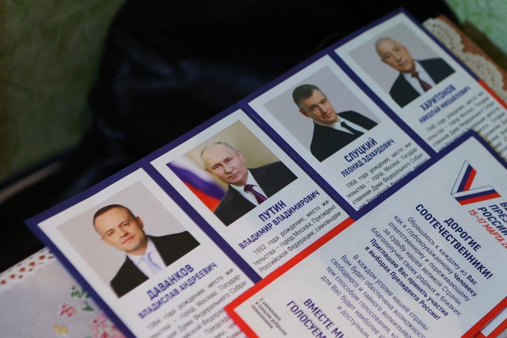 A leaflet displaying presidential candidates is seen on a table as local residents vote in their apartment during early voting for Russia's presidential election in Oktyabrsky, Belgorod region, on March 10, 2024. (Photo by STRINGER / AFP)
