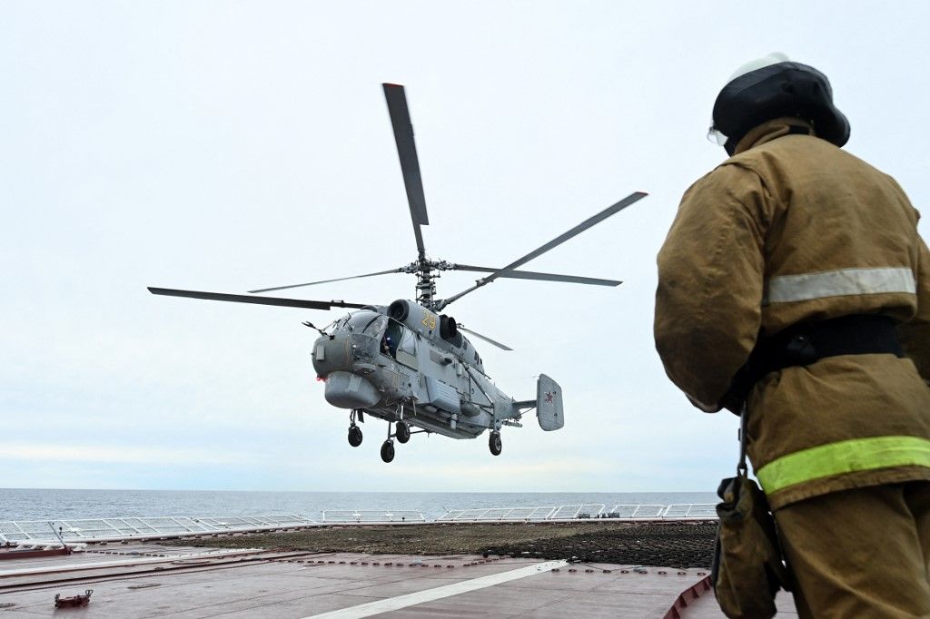 A Russian Ka-27PL military helicopter flies over the deck of the Marshal Shaposhnikov anti-submarine destroyer during the 'Vostok-2022' military exercises at the Peter the Great Gulf of the Sea of Japan outside the city of Vladivostok on September 5, 2022. The Vostok 2022 military exercises, involving several Kremlin-friendly countries including China, takes place from September 1-7 across several training grounds in Russia's Far East and in the waters off it. Over 50,000 soldiers and more than 5,000 units of military equipment, including 140 aircraft and 60 ships, are involved in the drills. (Photo by Kirill KUDRYAVTSEV / AFP)