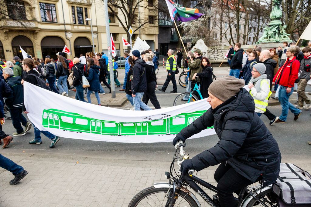 A mai napon a ver.di szakszervezet sztrájkolt, ez egy gyűjtő szakszervezet, nagyjából 1,5-2 millió taggal, és kb ezer különböző szakmát képviselnek. Ők felelnek a kollektív szerződésekért. A múlt havi mozdonyvezető sztrájk után most a közösség közlekedés/tömegközlekedési dolgozók sztrájkoltak, a jobb munkakörülményekért, meg fizetésemelésért. Tényleg brutál leterheltek, nagyon stresszes a meló, és itt is tervezett járatkimaradások vannak már (mint Budapesten), mert nincs elég buszsofőr, villamosvezető...stb.
KAV: Kommunaler Arbeitgeberverband - Kommunális Foglalkoztatók Szövetsége
Keine Ahnung (von) Verkehr : szóvicc a KAV-ból, kb Közlekedésből fogalmatlan
Verkehrswende: közlekedési reform, a Wende az a fordulat, váltás, új irány, rendszerváltás (ez a neve konkréten a 89-90es rendszerváltásnak) A közlekedés változtatása a közösségi közlekedés felé, kevesebb autó, több busz, több villamos, több bicikli...stb.
Wir fahren zusammen, wir streiken zusammen : Együtt utazunk, együtt sztrájkolunk. Kb, mint az egy csónakban evezünk.
Ob Bahn oder Bus, Sprinti ist ein Muss : Hogy vonat vagy busz, a Sprinti az kell!  (egy "muss"-muszáj)
Sprinti: gyorsbusz, iránytaxi,a külső "C" zónából a városba, vagy ott a C zónás utakra foglalható járat, kisbusz, amit appon keresztül lehet foglalni, de érvényes rá a bérlet (kb mintha über lenne BKV bérlettel)