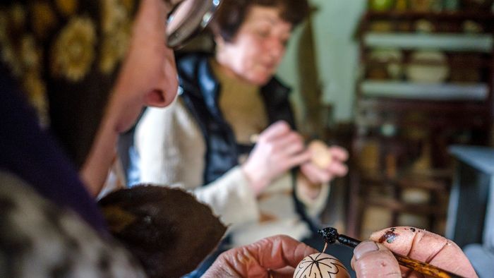 Méhviasz íróka segítségével írott tojást készít (balról jobbra) Gergely Irén, Ambrus Andrea és Nagy Viorica az erdélyi Gyimesközéplokhoz tartozó Hidegségpatakán