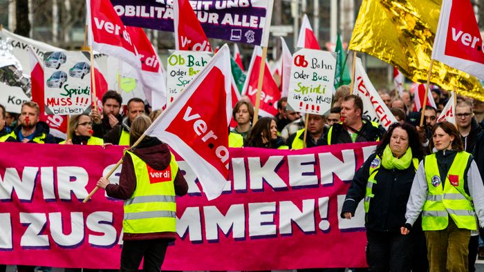 A mai napon a ver.di szakszervezet sztrájkolt, ez egy gyűjtő szakszervezet, nagyjából 1,5-2 millió taggal, és kb ezer különböző szakmát képviselnek. Ők felelnek a kollektív szerződésekért. A múlt havi mozdonyvezető sztrájk után most a közösség közlekedés/tömegközlekedési dolgozók sztrájkoltak, a jobb munkakörülményekért, meg fizetésemelésért. Tényleg brutál leterheltek, nagyon stresszes a meló, és itt is tervezett járatkimaradások vannak már (mint Budapesten), mert nincs elég buszsofőr, villamosvezető...stb.
KAV: Kommunaler Arbeitgeberverband - Kommunális Foglalkoztatók Szövetsége
Keine Ahnung (von) Verkehr : szóvicc a KAV-ból, kb Közlekedésből fogalmatlan
Verkehrswende: közlekedési reform, a Wende az a fordulat, váltás, új irány, rendszerváltás (ez a neve konkréten a 89-90es rendszerváltásnak) A közlekedés változtatása a közösségi közlekedés felé, kevesebb autó, több busz, több villamos, több bicikli...stb.
Wir fahren zusammen, wir streiken zusammen : Együtt utazunk, együtt sztrájkolunk. Kb, mint az egy csónakban evezünk.
Ob Bahn oder Bus, Sprinti ist ein Muss : Hogy vonat vagy busz, a Sprinti az kell!  (egy "muss"-muszáj)
Sprinti: gyorsbusz, iránytaxi,a külső "C" zónából a városba, vagy ott a C zónás utakra foglalható járat, kisbusz, amit appon keresztül lehet foglalni, de érvényes rá a bérlet (kb mintha über lenne BKV bérlettel)