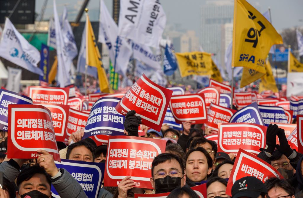 South Korean doctors hold placards saying "Opposition to theSEOUL, SOUTH KOREA - 2024/03/03: South Korean doctors hold placards saying "Opposition to the increase in medical schools" during the demonstration. Thousands of senior doctors held a rally in Seoul against the government's medical school quota hike plan as Prime Minister Han Duck-soo hinted at the possible suspension of medical licenses for striking trainee doctors. The rally by members of the Korean Medical Association (KMA), the biggest medical lobby group, came as thousands of trainee doctors have remained off their jobs at general hospitals for the 13th day, protesting the plan to add 2,000 more medical school seats starting next year. (Photo by Kim Jae-Hwan/SOPA Images/LightRocket via Getty Images)