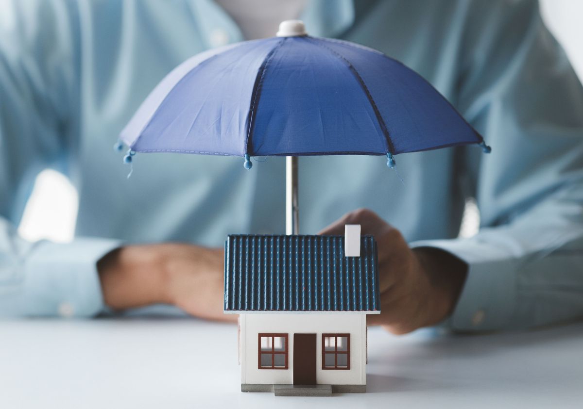 Individuals,Holding,Small,Umbrellas,And,Model,Homes,,Housing,Insurance,Against